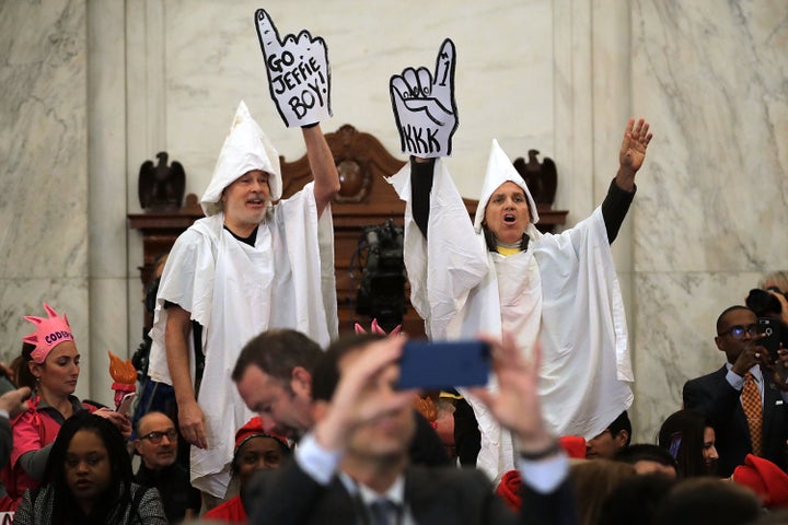 Protesters wearing white sheets shout at Sessions as he arrives for his confirmation hearing. 