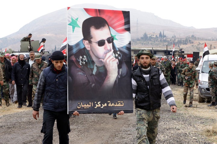 Syrian volunteers and their relatives wave the national flag and portraits of President Bashar al-Assad. 