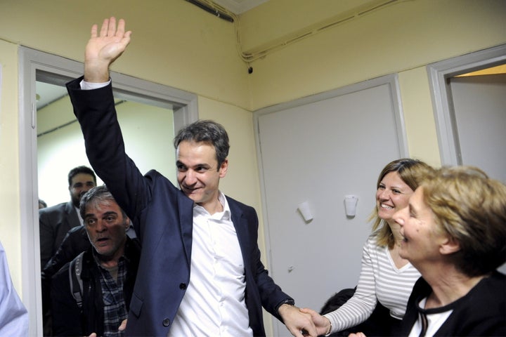 Kyriakos Mitsotakis, the newly elected leader of Greece's conservative New Democracy party, greets his supporters during his exit from his office in Athens, Greece. 