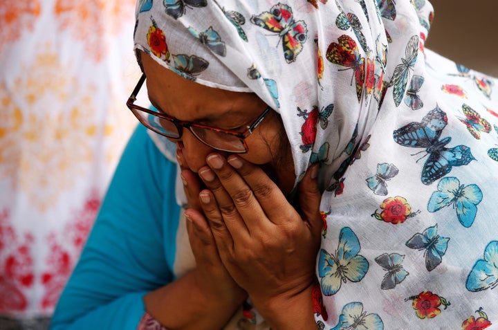 A woman mourns for the victims who were killed in the attack on the Holey Artisan Bakery and the O'Kitchen Restaurant, at a m