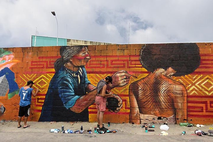 Mav Group from Valparaiso, Chile; Jonas Salio De La Ballena, Isaac Codomano, Cha AH and Juan Pablo Lopez Sepulveda paint the portrait of Favela Operaria resident Suellen Ferreira Santos. Meeting Of Favela 2016. Favela Operaria. Duque de Caxias. Rio De Janeiro, Brazil. 