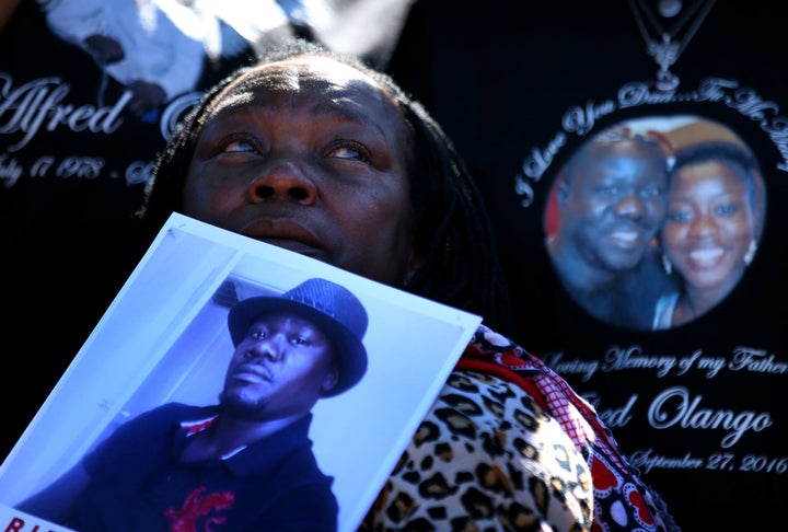 A woman holds a picture of Alfred Olango during a rally and march to protest the fatal police shooting of the Ugandan immigra