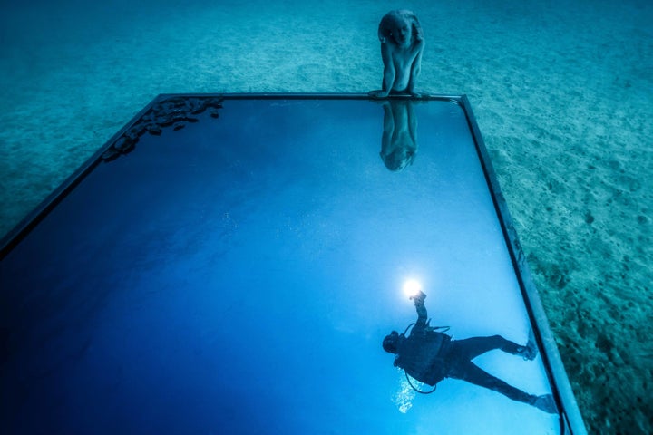 “Portal” is a half-human, half-animal creature looking into a mirror that reflects the ocean’s surface. The mirror is elevated on a platform with small compartments designed to attract octopuses, sea urchins and fish.