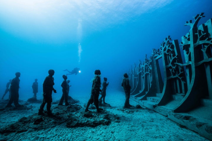 In “Crossing the Rubicon,” figures walk toward a wall that symbolizes our futile efforts to divide and control the ocean.