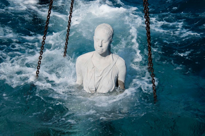 A figure is lowered into Museo Atlántico. The sculptures will be permanent and one day grow into working reefs.