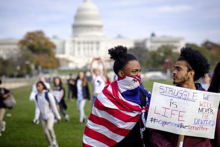 Protesters hold signs while demonstrating during a rally against U.S. President-elect Donald Trump in Washington, D.C., Nov. 15, 2016.