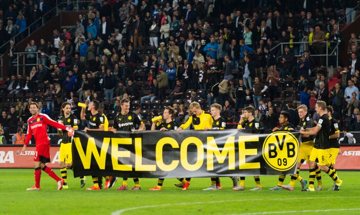 The teams of FC St. Pauli and Borussia Dortmund welcome refugees during the friendly match between FC St. Pauli and Borussia Dortmund at Millerntor-Stadion on September 8, 2015 in Hamburg, Germany. 