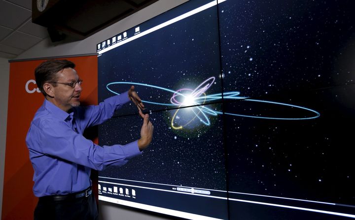 Professor of Planetary Astronomy Mike Brown speaks in front of a computer simulation of the probable orbit of Planet Nine.