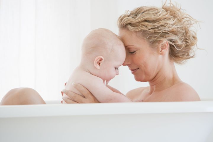 Mother and baby bathing Tom Merton via Getty Images