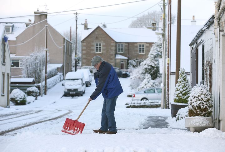 A man clears snow from his driveway in Braco, near Stirling