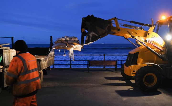 Workers unload sandbags near to water front shops and businesses ahead of expected high seas in Saltburn-By-The-Sea, North Yorkshire