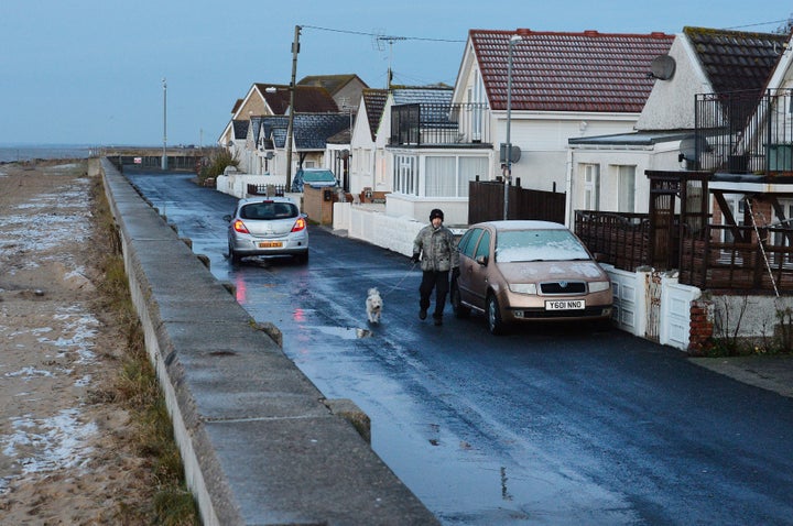 A resident walks his dog along Brooklands Road in Jaywick, Essex, from where police were preparing to evacuating residents amidst fears of flooding caused by a tidal surge on Friday afternoon 