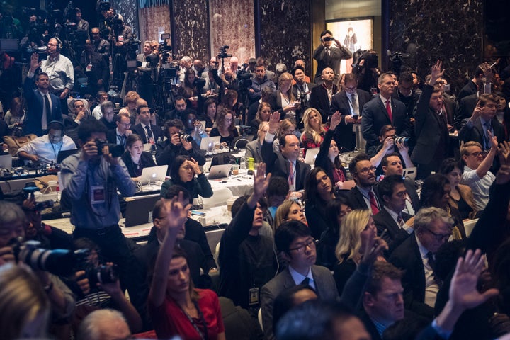 Members of the media raise their hands to try and ask questions as President-elect Donald Trump speaks during a press confere