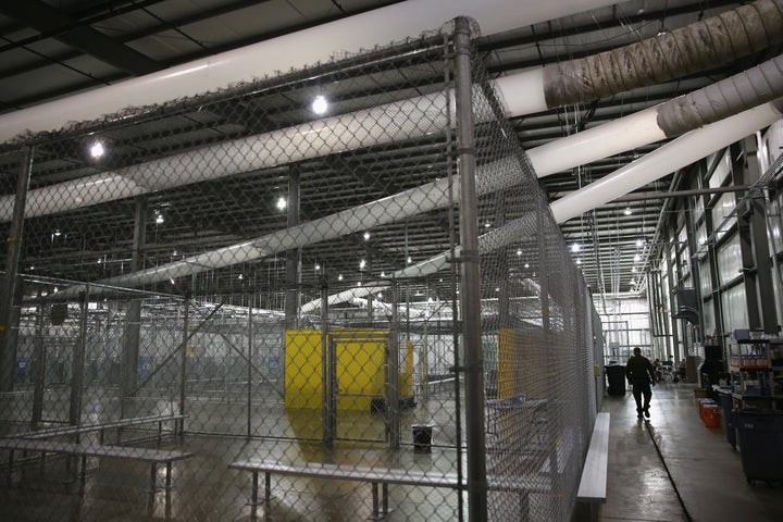 A U.S. Border Patrol agent walks through a detention facility run by the Border Patrol on September 8, 2014 in McAllen, Texas