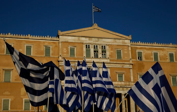 The Greek Parliament is seen behind flags. 