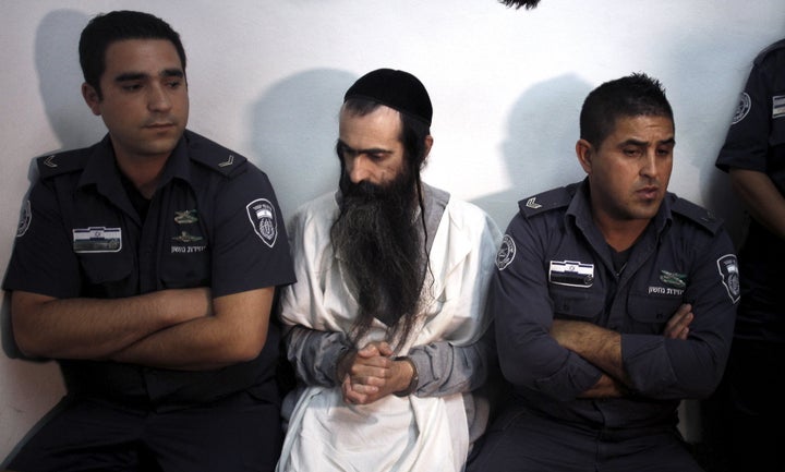 Yishai Schlissel (C) is escorted by security personnel at the Jerusalem Magistrates Court July 31, 2015. 