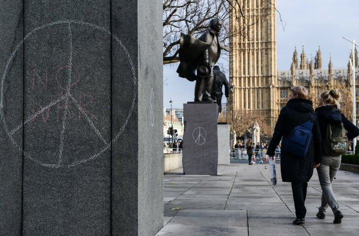 Peace symbols and “no war” drawn on political sculptures in Parliament Square on Dec. 2, 2015, in London.