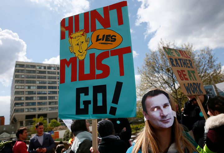 A junior doctor wears a mask baring Hunt's face during a junior doctors strike last year