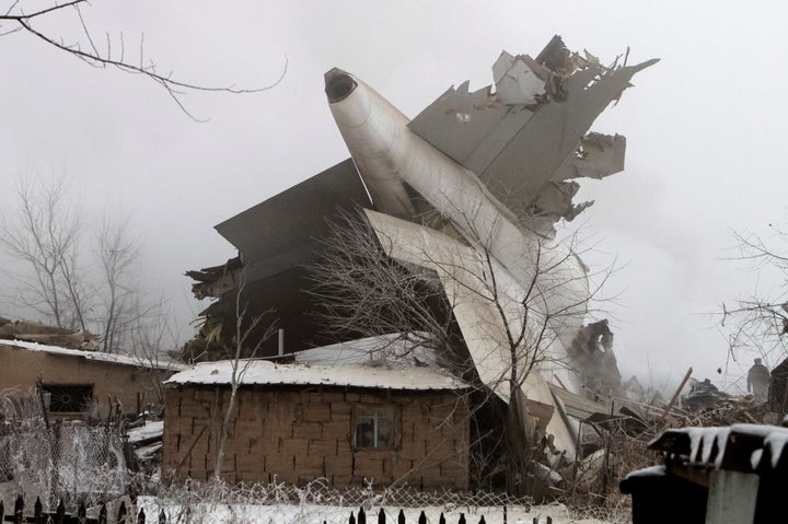 The plane's tail atop a house.