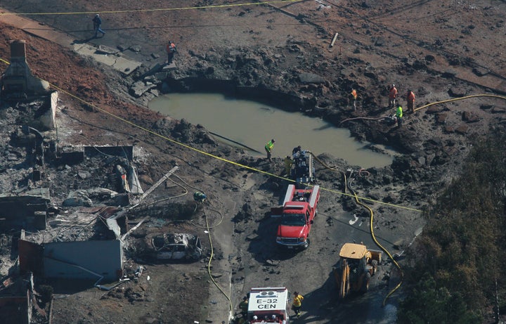 Firefighters investigate a massive crater at the scene of a gas main explosion September 10, 2010 in San Bruno, California. Thirty eight homes were destroyed and four people were killed when a Pacific Gas and Electric gas main blew up in a San Bruno, California neighborhood near San Francisco International Airport on Thursday evening. (Photo by Justin Sullivan/Getty Images)