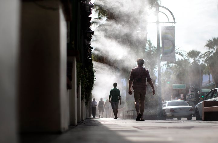 Pedestrians walk under cooling misters in Palm Springs, California, where the temperatures reached the high 90s on Oct. 12, 2015, while most of Southern California suffered under a heat wave.
