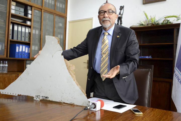 The head of Mozambique's Civil Aviation Institute, Comandante Joao Abreu, shows a piece of debris believed to be from MH370