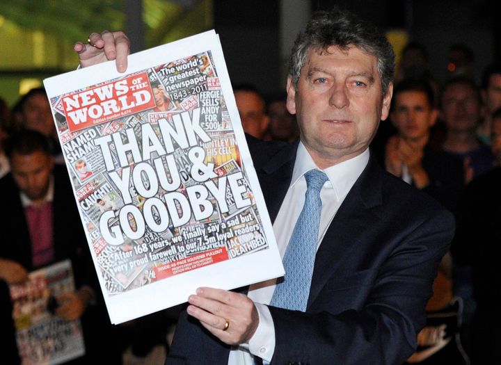 Colin Myler, editor of the News of The World, holds up a copy of the last edition of the newspaper outside the newspaper's office in Wapping, east London, on July 9, 2011.