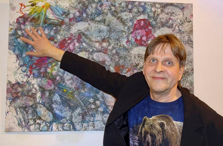 Pasi Jantti a keeper of a bear called Jusso points on the painting at the gallery in Helsinki, Finland. Juuso, an orphaned br