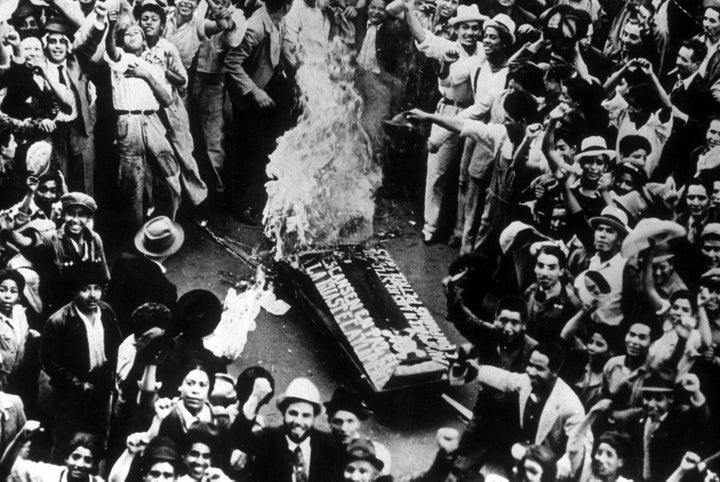 Crowds cheering as a coffin, representing an oil coffin, burns during celebrations in Mexico City of the government appropriation of foreign-owned properties.