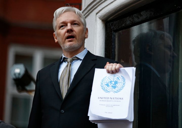 WikiLeaks founder Julian Assange holds a copy of a U.N. ruling that he should be allowed to go free the balcony of the Ecuadorian Embassy in London on Feb. 5, 2016.