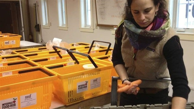 A worker at Intervale Food Hub in Burlington, Vermont, packages carrots as part of a weekly delivery of locally grown food.