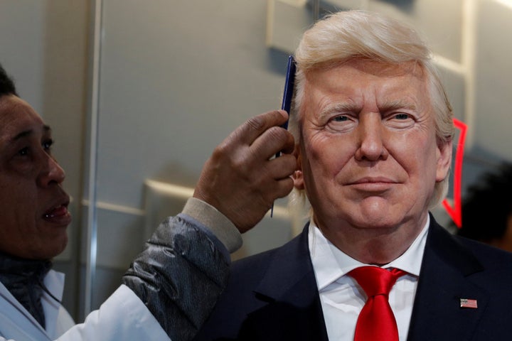 A technician combs the hair of a waxwork of U.S. President-elect Donald Trump at the Musee Grevin in Paris, Jan. 19, 2017.