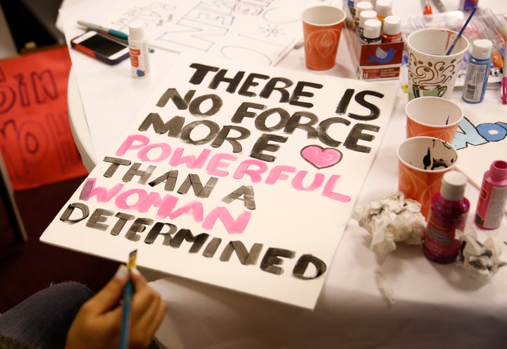 A woman works on a sign for the upcoming Women's March on Washington in Boston on Jan. 16, 2017.