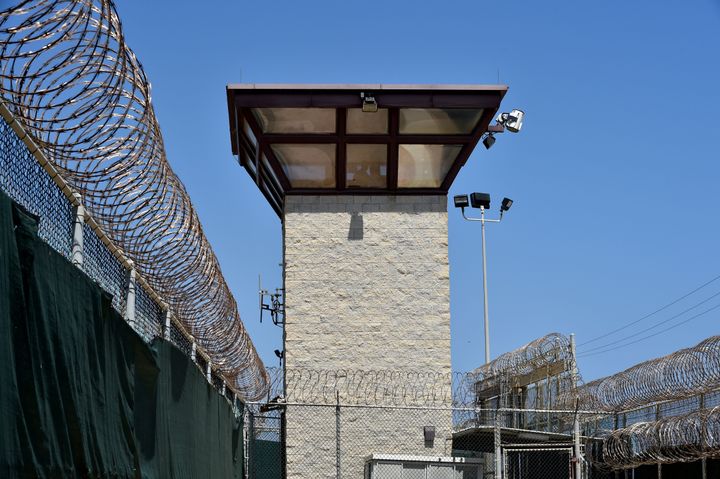 Fences topped with razor wire and a watch tower mark the Guantanamo prison camp.