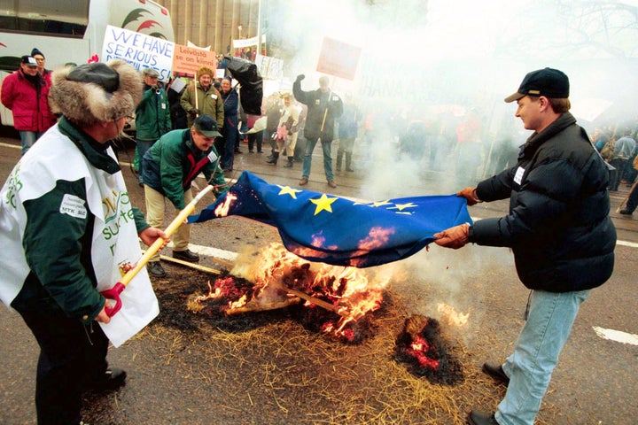 Finnish farmers demonstrating in front of the parliament building burn the European Union flag as they protest EU agriculture policy in Helsinki.