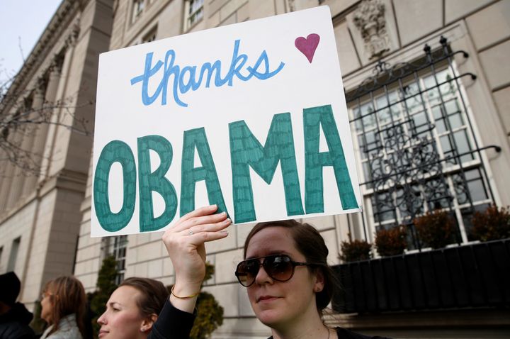 A woman holds a sign thanking him outside the White House