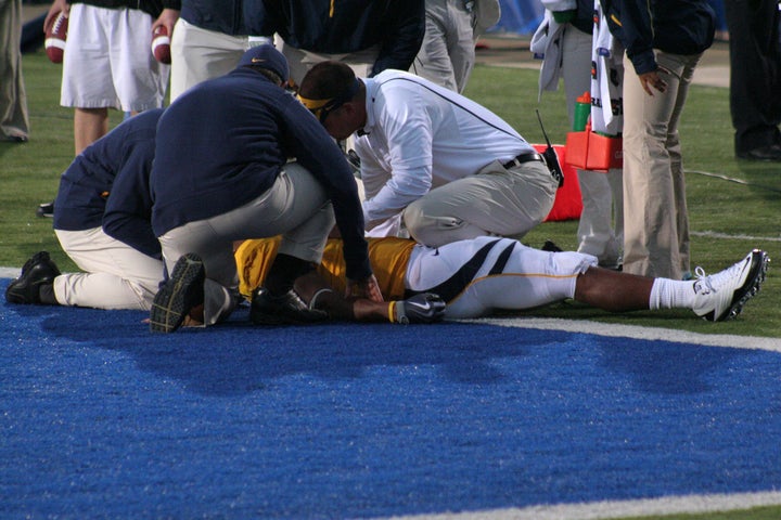 A player is examined for a concussion on the field. 