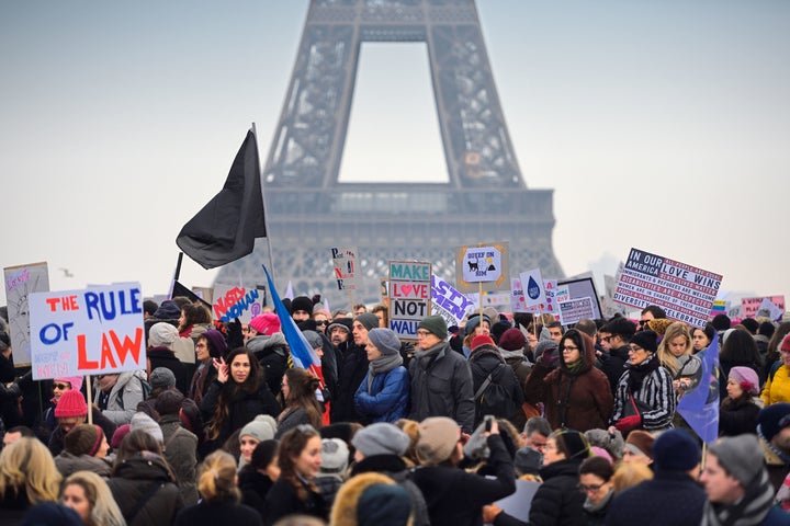 Demonstrators carry placards on Saturday in Paris during a rally in solidarity with supporters of the Women's March on Washington.