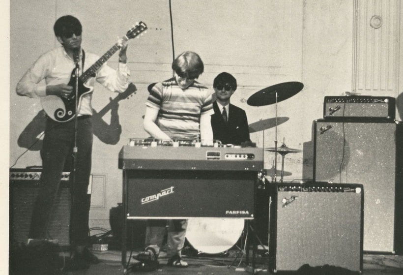 Ray Riepen (at right) poses behind drums at the Boston Tea Party.