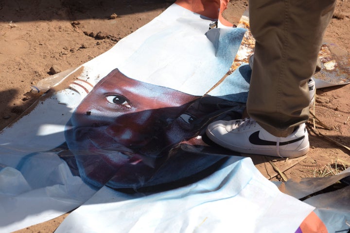 A man walks on a ripped electoral poster of Gambia's outgoing president Yahya Jammeh, in a street of Bijilo, on December 4, 2016.