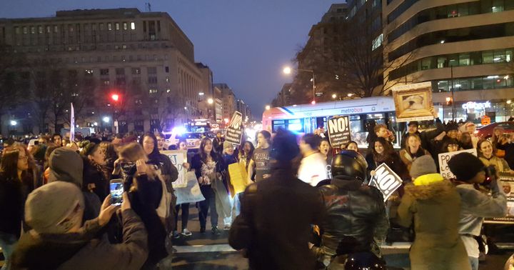Protestors block buses and cars while shouting grievances with the incoming Trump Administration.
