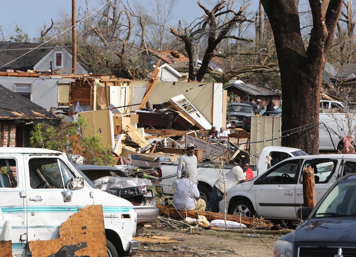 Residents of Magnolia Street in Hattiesburg, Miss., take a break from cleaning up after a tornado hit the area on Saturday, J