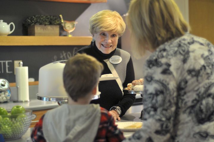 Mary Bochanis, who has volunteered at the Children's Inn at the NIH for over 26 years, serves breakfast to a family.