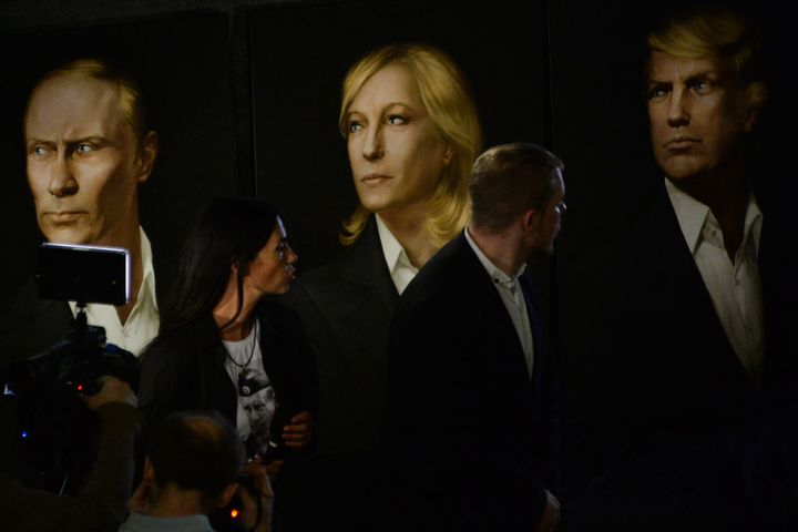 People speak in front of a portraits Putin, Trump and France's far-right Front National's Marine Le Pen during a Trump inauguration ceremony party in Moscow, on Jan. 20, 2017.