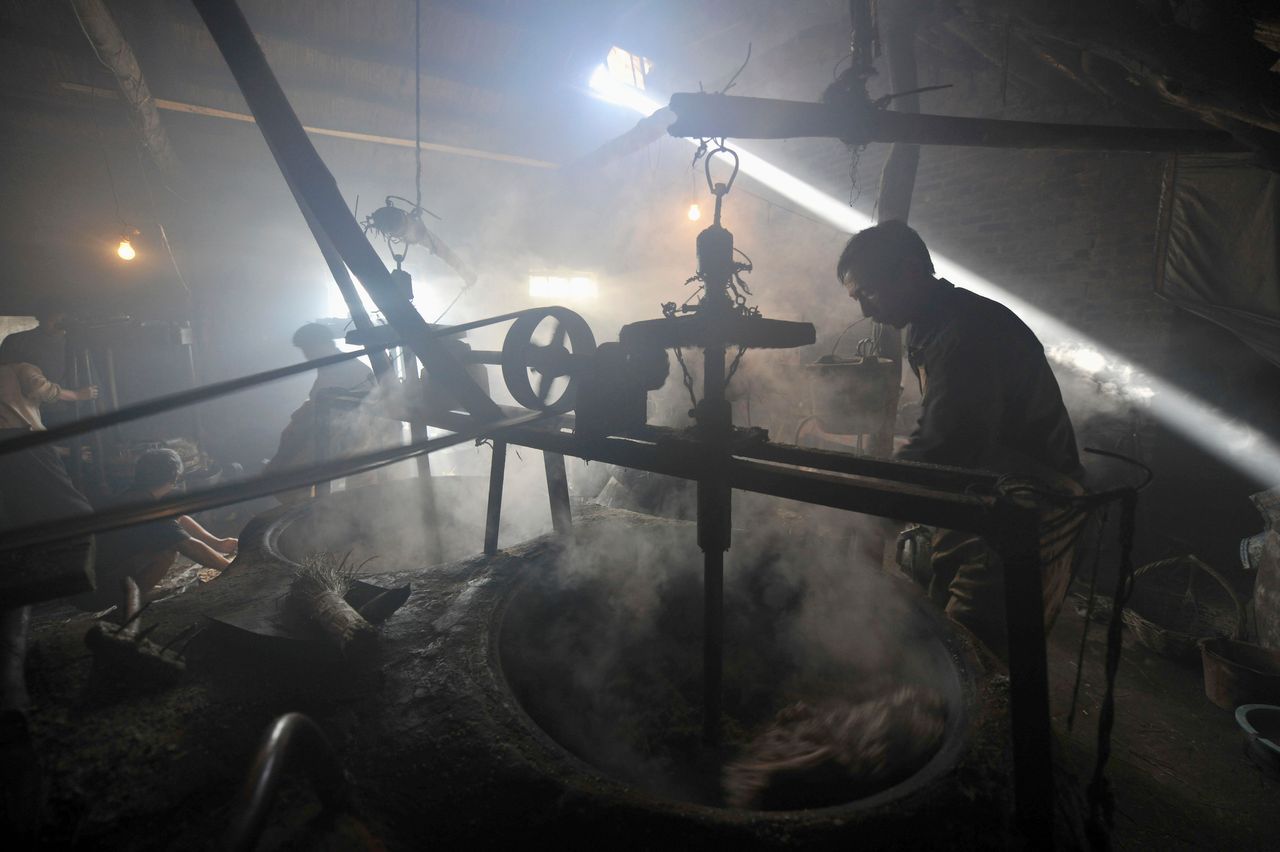 A laborer uses a machine to stir crushed peanuts at a workshop in Rizhao. Dec. 11, 2010.