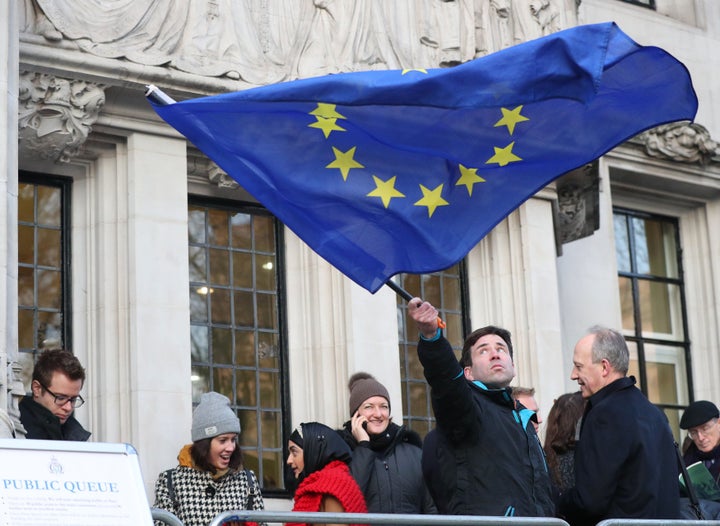 A man waves a flag outside the Supreme Court in London ahead of the ruling