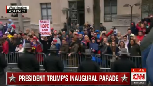 Michael Walker holding a FINALLY HOPE AND CHANGE sign as President Trump's inaugural motorcade rolls down Pennsylvania A