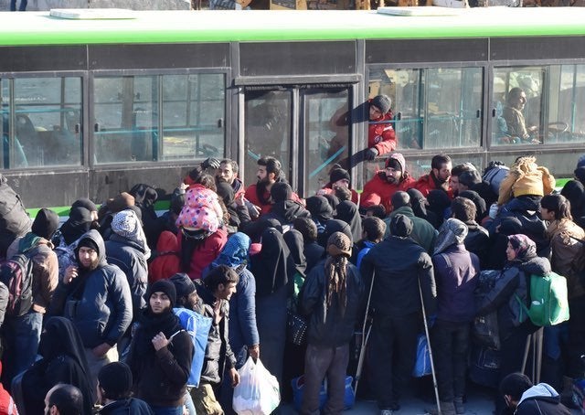 Civilians from east Aleppo, which was under siege by forces of the Assad regime and its foreign supporters, wait for evacuati