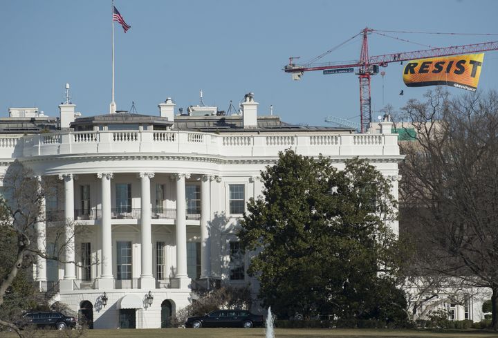 Greenpeace protesters unfold a banner from atop a construction crane near the White House on Wednesday.