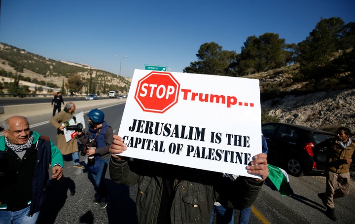 A Palestinian demonstrator holds a placard during a protest against Trump, Jan. 20, 2017.